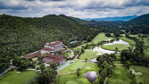 an aerial view of a golf course with a building and a river at Alpine Golf Resort Chiang Mai in Ban Huai Sai Nua