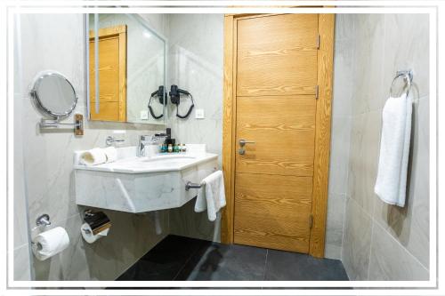 a bathroom with a sink and a mirror and a door at Premium Hotel Ganja in Ganja