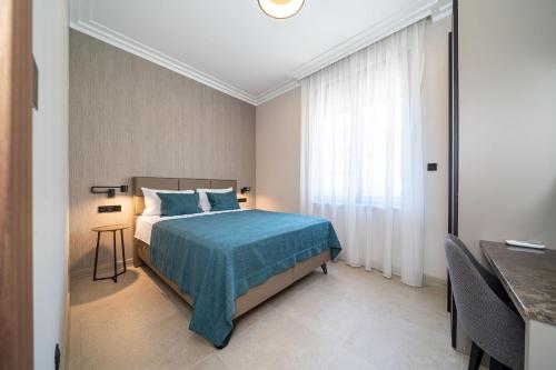 a bedroom with a bed and a table and a window at C Group apartments in Kotor