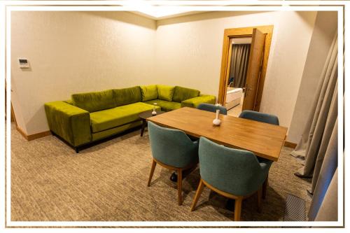 a living room with a green couch and a table at Premium Hotel Ganja in Ganja