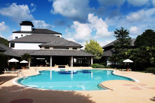 a large swimming pool in front of a building at Alpine Golf Resort Chiang Mai in Ban Huai Sai Nua