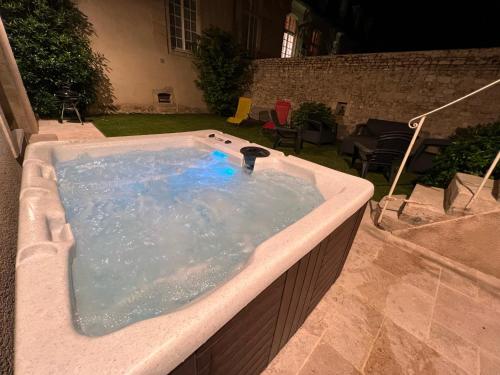 a jacuzzi tub in a yard with a patio at Maison d'Alice - avec SPA in Bayeux