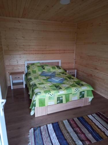 a bedroom with a bed in a wooden room at Cabane Areama Neagra in Izvoru Mureşului