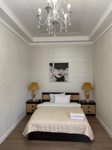 a bedroom with a large bed and a chandelier at Bonus in Vinnytsya