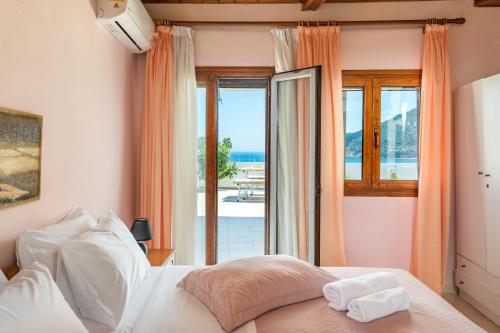 a bedroom with a bed with a view of the ocean at Regina Hotel in Skopelos Town