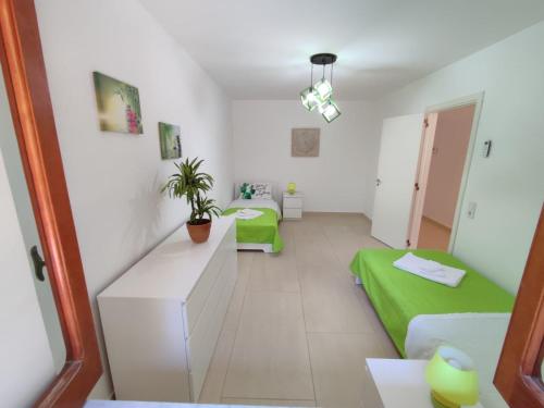 een kamer met 2 bedden en een groene bank bij Kalura Sea House in Cefalù