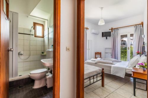 a bathroom with a bed and a toilet and a sink at Regina Hotel in Skopelos Town