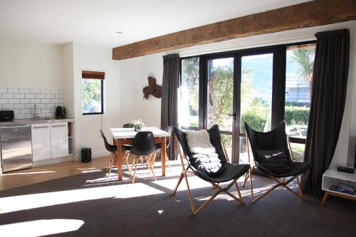 a living room with a dining room table and chairs at Sunny Lakeside Haven in Queenstown