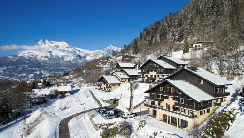 un lodge dans la neige avec des montagnes en arrière-plan dans l'établissement Studio & piscine intérieure, vue Mont D'Arbois, à Saint-Gervais-les-Bains