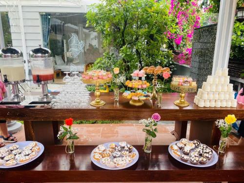 a table filled with plates of food and desserts at Window Homestay in Kon Tum