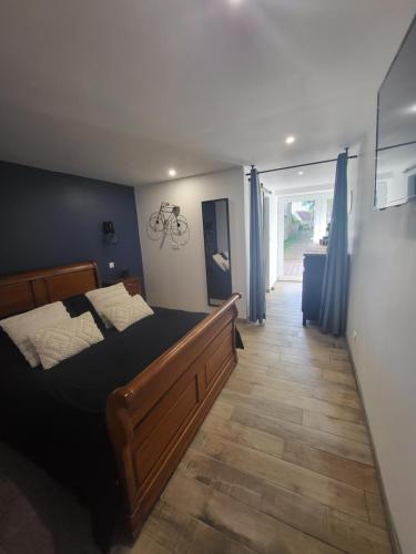 a bedroom with a large bed with a wooden floor at Les gîtes de ninon in Moult