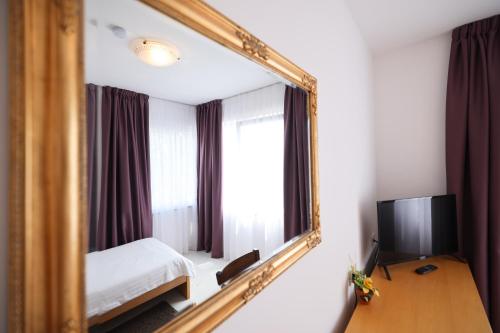 lustro w pokoju z łóżkiem i telewizorem w obiekcie Depadansa Hotel Lucija*** w mieście Posedarje