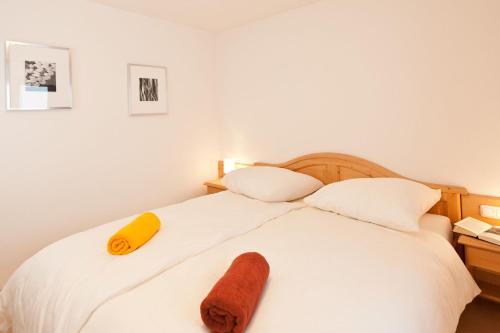 ボルシュターラングにあるFerienwohnungen Alpentraum - Traumblickのベッドルーム1室(白いベッド1台、黄色いタオル付)