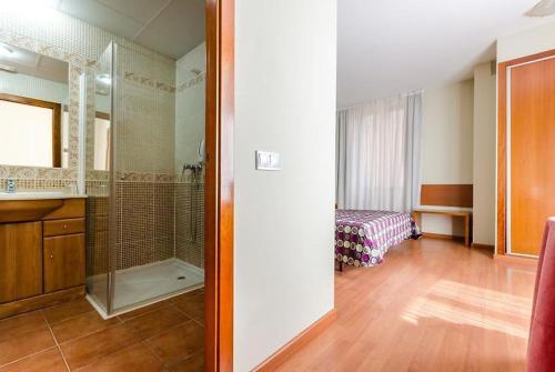 Un baño con ducha, lavabo y espejo. en Ele Mirador de Santa Ana, en Ávila