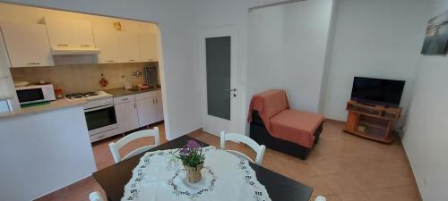 a living room with a table and a kitchen at Danijela Apartment in Pula
