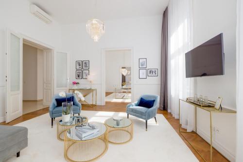 a living room with two blue chairs and a tv at RAFAEL KAISER - Premium Apartments City Centre - Contactless Check-In in Vienna