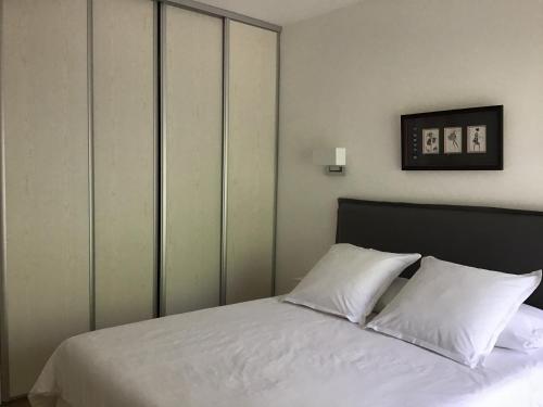 - une chambre avec un lit doté de draps et d'oreillers blancs dans l'établissement Grand T2 5min du centre historique D'Aix en Provence, à Aix-en-Provence