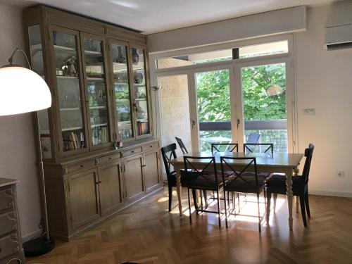 d'une salle à manger avec une table, des chaises et une fenêtre. dans l'établissement Grand T2 5min du centre historique D'Aix en Provence, à Aix-en-Provence