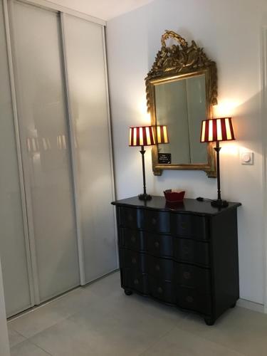 a bedroom with two lamps on a dresser and a mirror at Grand T2 5min du centre historique D'Aix en Provence in Aix-en-Provence
