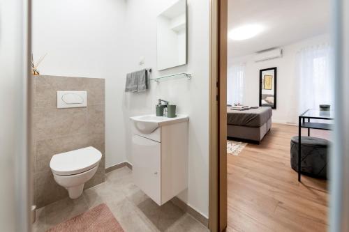 een badkamer met een toilet, een wastafel en een bed bij Adriatic Dream Rooms in Rovinj