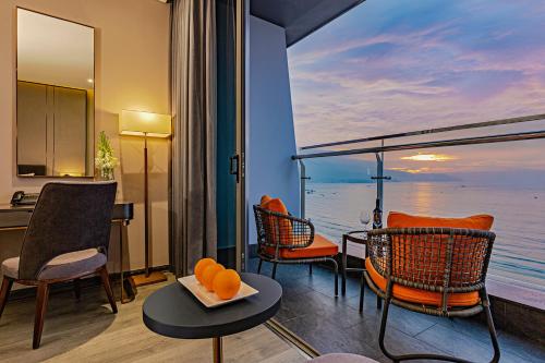 a room with chairs and a view of the ocean at Le Sands Oceanfront Danang Hotel in Da Nang