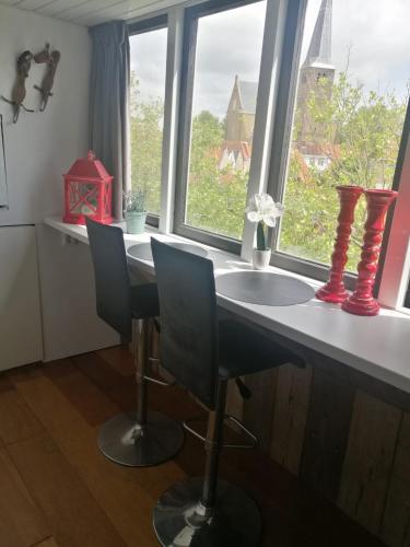 a kitchen with a table and two chairs and a window at WitteZwaan in Harlingen