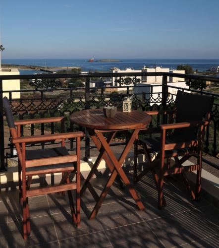 a wooden table and two chairs on a balcony at Anemoni in Dhiakofti