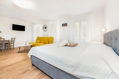 een witte slaapkamer met een bed en een eetkamer bij Adriatic Dream Rooms in Rovinj