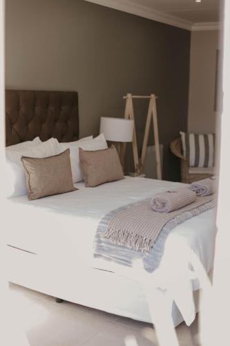 a large white bed with two pillows on it at Villa Rose Guesthouse & Venue in Bloemfontein