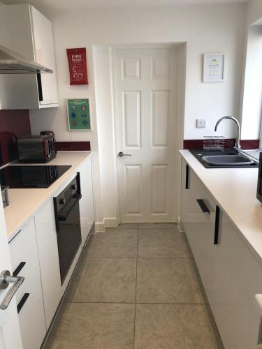 a kitchen with white counters and a white door at Highfield House - 1 Bed-Sleeps 2-TJS20HH in Ilfracombe