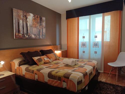 a bedroom with a bed and a large window at A PONTE in Padrón