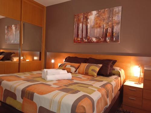 a bedroom with a large bed with two lamps on it at A PONTE in Padrón
