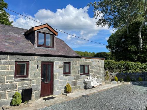 een stenen cottage met een rode deur bij Snowdonia Holiday Cottages in Conwy