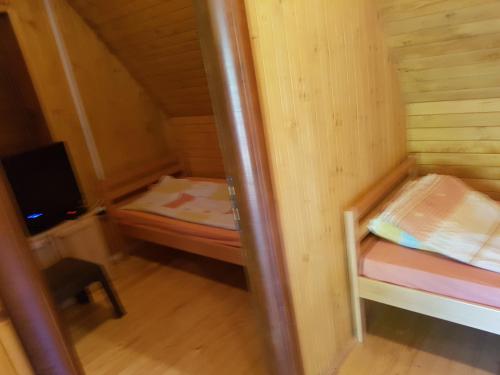 Kleines Zimmer mit einem kleinen Bett und einem TV. in der Unterkunft Bungalov DeLux in Konjic