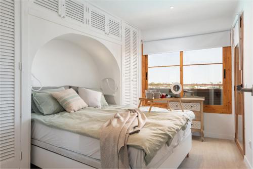 a bedroom with a bed with a white headboard at Beachside Alcudia in Alcudia