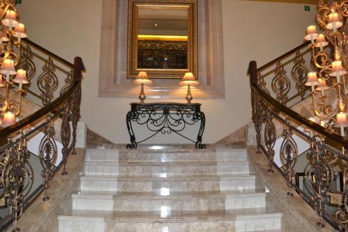 a staircase with wrought iron railings and a mirror at Sheraton Khalidiya Hotel in Abu Dhabi