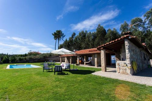 a stone building in a yard with a pool at Quinta da Bela Vista, Ribas, Celorico de Basto in Celorico de Basto