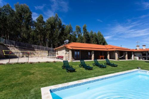 a swimming pool in a yard with chairs and a house at Quinta da Bela Vista, Ribas, Celorico de Basto in Celorico de Basto