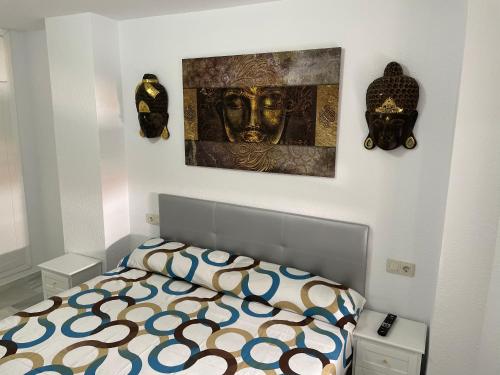 una camera da letto con un letto e un dipinto sul muro di Apartamento BudhaZahara a Zahara de los Atunes