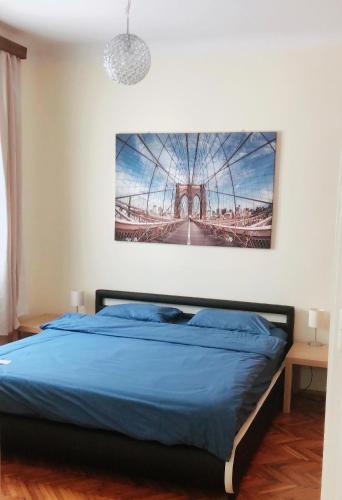 ein Schlafzimmer mit einem blauen Bett mit einem Bild an der Wand in der Unterkunft W&M Stylish Apartment in Budapest