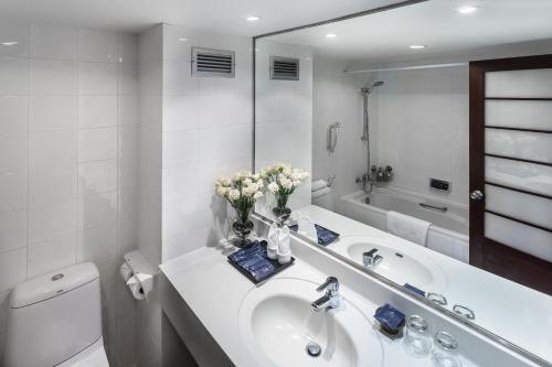 a bathroom with a sink and a toilet and a mirror at Alpine Golf Resort Chiang Mai in Ban Huai Sai Nua