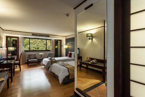 une chambre d'hôtel avec une chambre et un salon dans l'établissement Alpine Golf Resort Chiang Mai, à Ban Huai Sai Nua