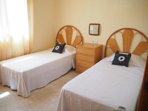 レスタルティットにあるCasa en l'Estartit, piscina, jardín comunitarioのベッド2台とドレッサーのある寝室