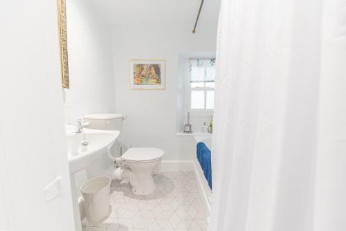 a white bathroom with a toilet and a sink at Self check in cosy country retreat in Lancaster