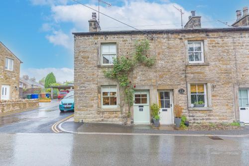 a stone building on a street with a car parked outside at Self check in cosy country retreat in Lancaster