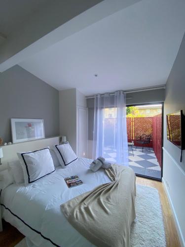 a bedroom with a bed and a large window at LES CHAMBRES DE MARIE in Bordeaux