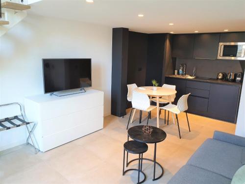 - un salon avec une table, des chaises et une télévision dans l'établissement Duplex centre mer 405, à Nice