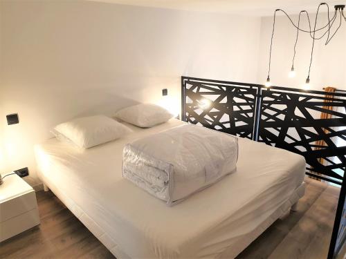 - une chambre avec un lit doté de draps blancs et d'un cadre noir dans l'établissement Duplex centre mer 404, à Nice