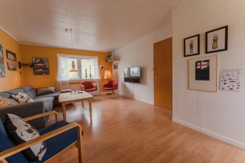 een woonkamer met een bank en een tafel bij Scenic Village / Nature / Cozy House / 4 BR in Viðareiði