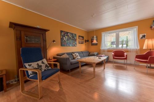 een woonkamer met een bank en een tafel bij Scenic Village / Nature / Cozy House / 4 BR in Viðareiði